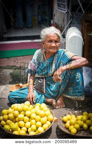Mumbai, India - 5 August: An old woman sells lemons at Colaba Market in Mumbai, India
