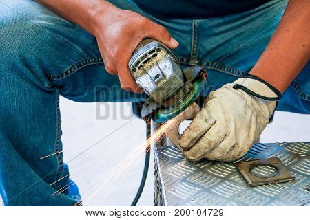 Worker Using Angle Grinder In Factory And Throwing Sparks. Electric Grinder Metal With Worker Cuttin