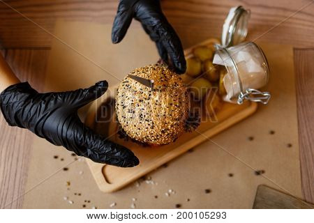 A view from above on a fast food composition on a wooden table background. Fat meat burger and rustic potatoes on a wooden tray. Junk food. American burger. Cooking, fast food, concept.