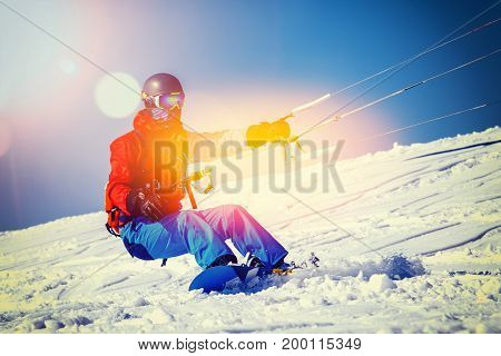 Snowboarder with a kite on fresh snow in the winter in the tundra of Russia against a clear blue sky. Teriberka, Kola Peninsula, Russia. Concept of winter sports snowkite.