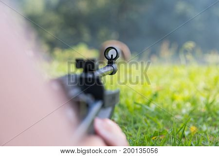 A Man Shoots A Target From A Pneumatic Gun. A View From Behind The Shoulder