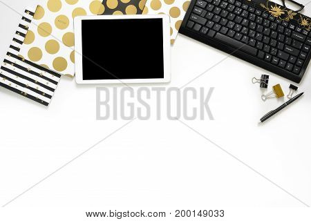 Flat Lay Photo Of Office White Desk With Tablet, Keyboard And Gold Notebook Copy Space Background