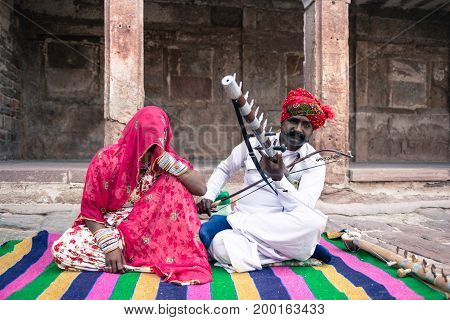 JODHPUR RAJASTHAN INDIA - MARCH 05 2016: Wide angle picture of indian couple playing local music inside Mehrangarh Fort in Jodhpur the blue city of Rajasthan in India.