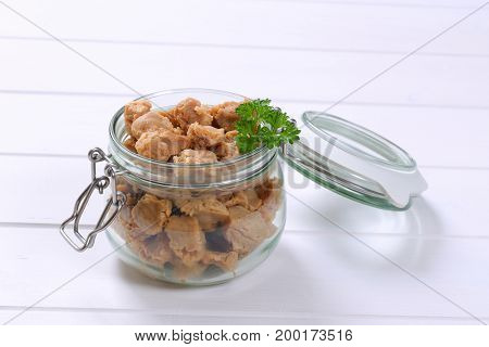 jar of soy meat cubes on white wooden background