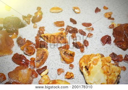 Amber. the pieces of amber in the sand on the beach. Sun stone natural mineral on the beach. Amber Shine on the beach. Amber Baltic sand