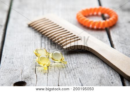 Hair Nurishment. Vitamin Serum Capsule On Wooden Background