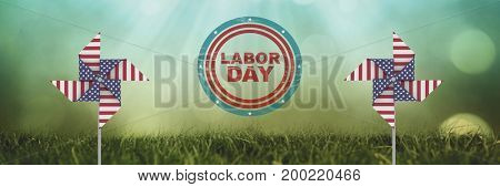 Digital composite of labor day text and USA wind catchers in front of grass and sky