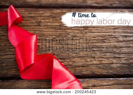 Digital composite image of time to happy labor day text against close-up of red ribbon
