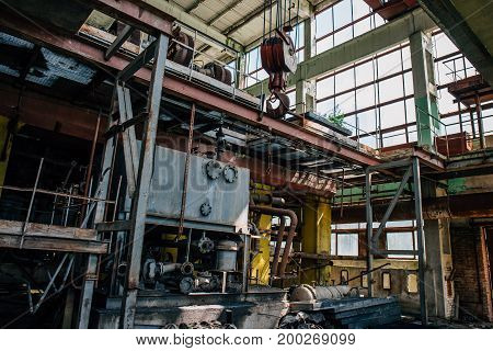 Abandoned factory inside interior with equipment, iron rigs, pipes, toned