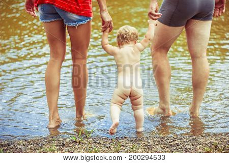 The child learns to walk in the park barefoot on the grass
