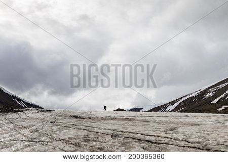 Man walking away in the distance, on a glacier in Longyearbyen, Svalbard.