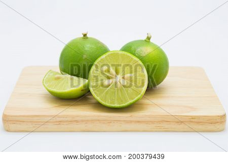 Green slide limes on wooden borad on white background