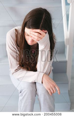 A woman sitting alone and depressed at home