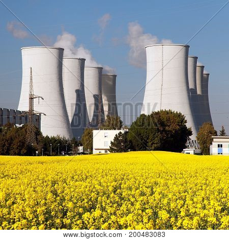 Panoramic view of Nuclear power plant Jaslovske Bohunice with golden flowering field of rapeseed - Slovakia - two possibility for production of electric energy