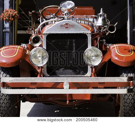 Charlottetown, Prince Edward Island - August 21, 2011 - Squared close up straight view of the front of an antique 1929 Fire Truck on display in front of a Firehouse in Charlottetown, Prince Edward Island on a bright sunny day in August.