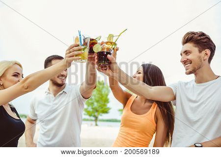 Friends having fun at the bar outdoors, drinking cocktails. Summer bar