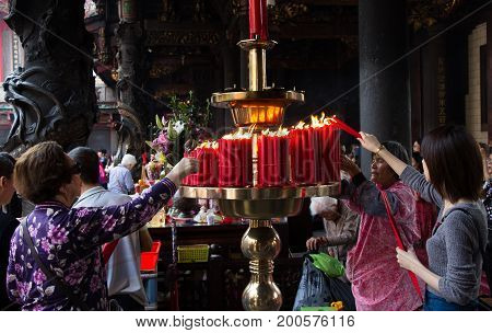 Taipei Taiwan - March 20 2015: Buddhists set fire on candles in Longshan temple