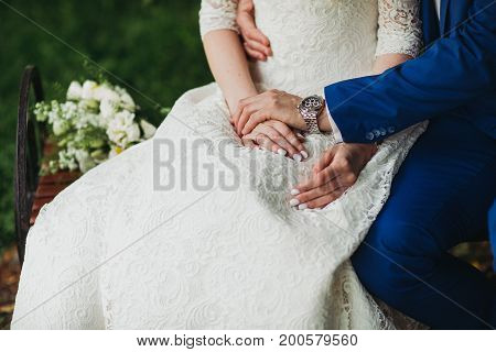 Bride and groom holding hands outdoors daylight