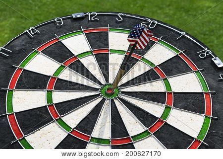 Metal darts have hit the red bullseye on a dart board. Darts Game. Darts arrow in the target center darts in bull's eye close up. Success hitting