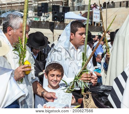 JERUSALEM, ISRAEL - OCTOBER 12, 2014: Morning autumn Sukkot. The area in front of the Western Wall of the Temple filled with people. Many brought prayer books and four ritual plants
