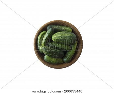 Fresh сucumbers in wooden bowl isolated on white background. Top view. Cucumbers with copy space for text.