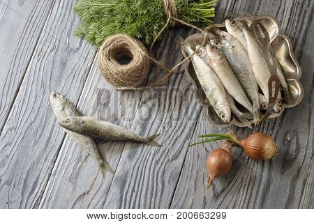 Fresh fish boops and vegetables on wooden table close-up.