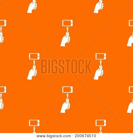 Hand holding a selfie stick with mobile phone pattern repeat seamless in orange color for any design. Vector geometric illustration