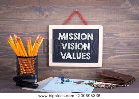 Mission, Vision and Values. Chalkboard on a wooden background.