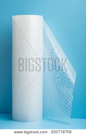 Roll of bubble wrap on blue background