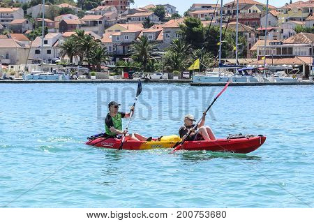 TROGIR, CROATIA - JULY 11, 2017: Tourists swim by boat along the bay in the town of Trogir, Croatia.