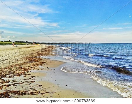Beach in Marielyst denmark with ocean waves of baltic sea and blue sky