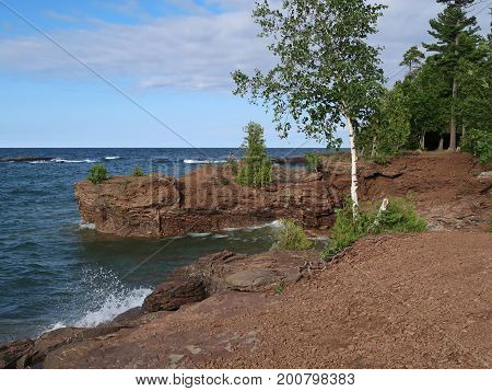 Blue waters of Lake Superior splash against the rockbound shore of Presque Isle Park in Marquette in the upper peninsula of Michigan.