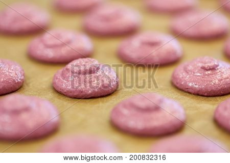 cooking, food and confectionery concept - macaron batter or meringue cream on baking paper at pastry shop