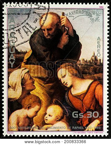 Moscow Russia - August 22 2017: A stamp printed in Paraguay shows painting "Holy Family" by Raphael series "The 500th Anniversary of the Birth of Raphael 1483-1520 - Christmas" circa 1982