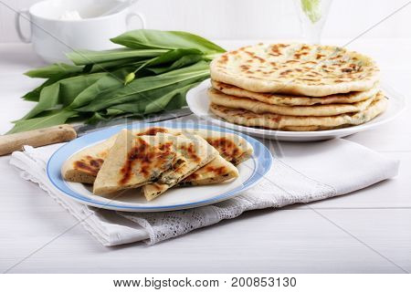Khychiny - traditional caucasian flatbread filled with сheese and herbs. Flat bread stuffed with feta and wild garlic.