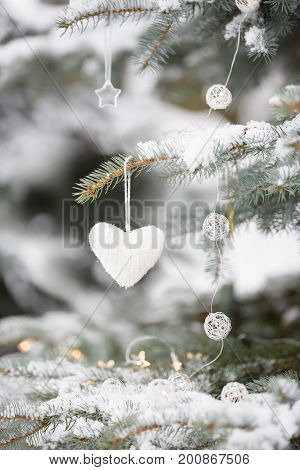 Nice decorations on a Christmas tree with snow outdoors. Celebration winter and holidays concept