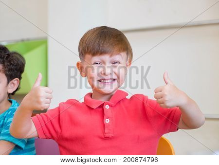 Kindergarten kid smile and thumbs up classoom at preschool internationaleducation concept