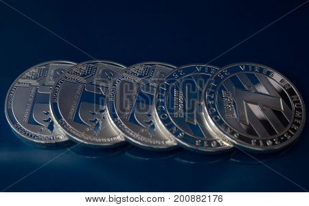 On a blue background are coins of a digital crypto currency Litecoin.