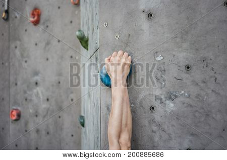 Close-up of asian male Climbing focus on right hand
