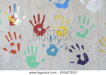 Color hand prints over a concrete wall. red yellow green and blue paint. Good as a background image.