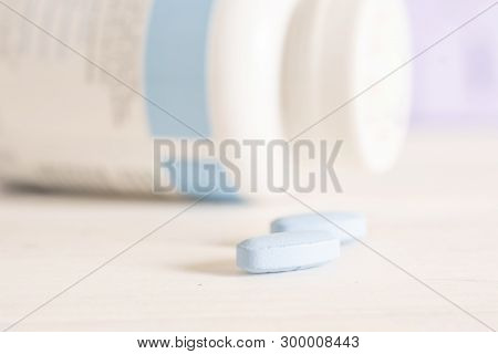 Group Of Two Whole Blue Drugs With A White Bottle On The Table In A Hospital
