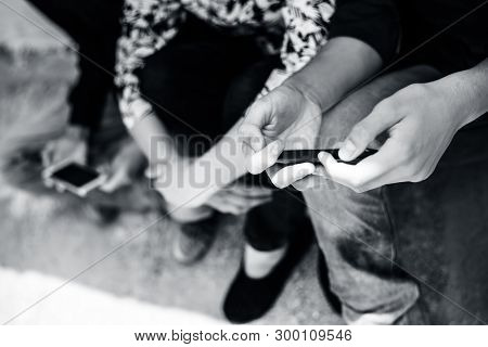 Group Of Multi-ethnic Teenagers Spending Free Time With Friends By Sitting,playing Games In Smart Ph