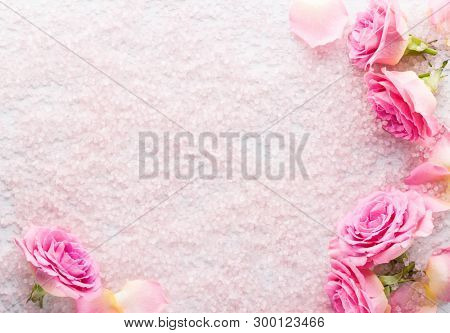 Spa salt crystals and  pink roses.  Flat lay.