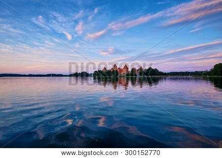 Trakai Island Castle in lake Galve, Lithuania on sunset with dramatic sky reflecting in water. Trakai Castle is one of major tourist attractions of Lituania
