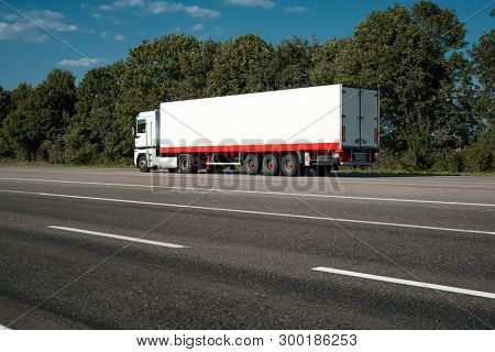 White truck is going up the road. Cargo transportation concept.