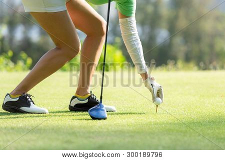 Hand Asian Sporty Woman Putting Golf Ball On Tee With Club In Golf Course On Evening On Time For Hea
