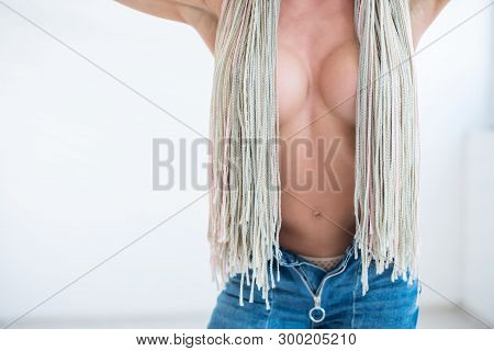 Torso Of Female Athlete With Silicone Bare Breasts. A Blonde In Jeans With A Beautiful Figure Covere