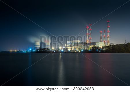 Old Thermal 450 Megawatt Power Plant At Night With Artificial Lake On Foreground