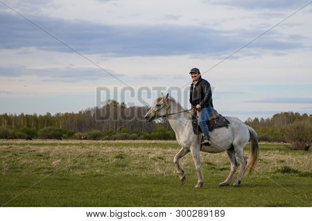 A Fermer On A White Horse In The Field