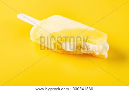 Side View Yellow Popsicle With Bites On A Yellow Background